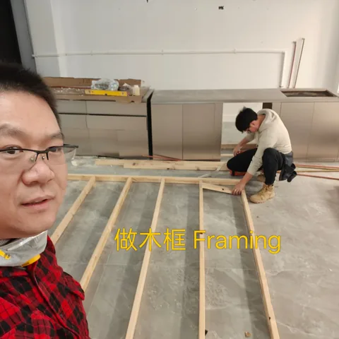 Timber frame laid out on a floor with a second worker fixing battens
