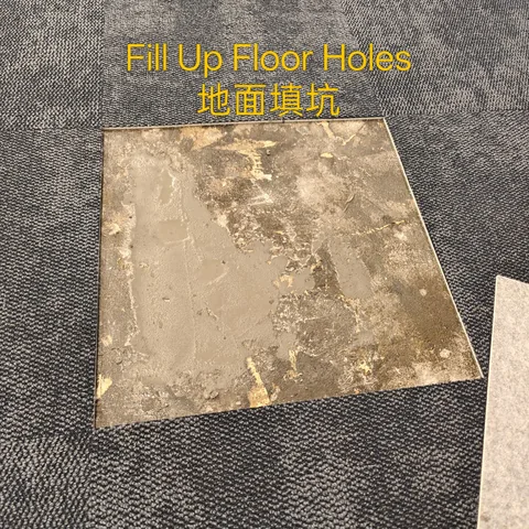 Square section of floor filled flush with levelling compound beside carpet tiles