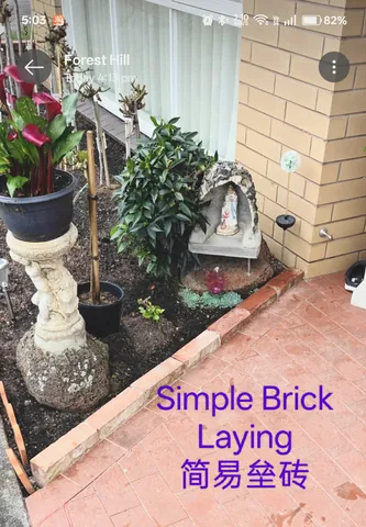 Single-course brick edging laid between a garden bed and a paved path